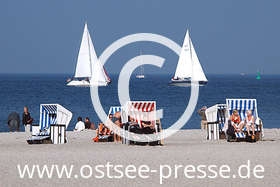 Ein sonniger Herbsttag am Strand, Segelyachten gleiten über das Wasser